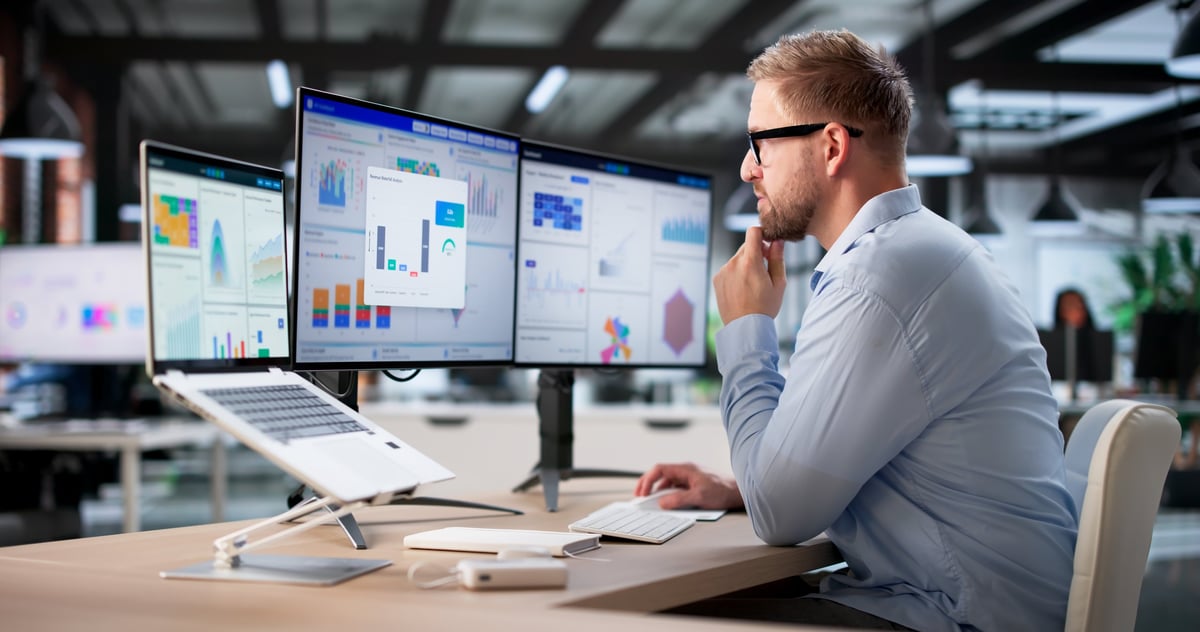 Business analyst monitoring sales metrics on a screen in an office